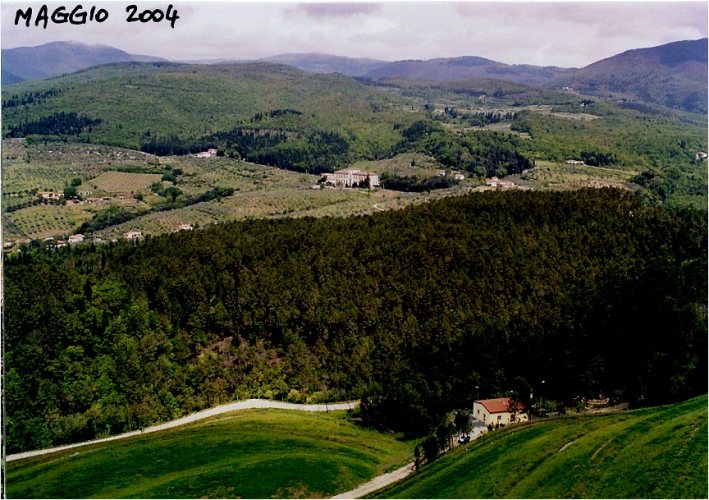 panoramica dal costone della ex cava di serpentino delle Volpaie ai Sassi Neri verso la valle del torrente Bagnolo, si vedono in basso a dx il centrovisite, il corpo della discarica a dx e sx ricoperto da un verde manto erboso, sgombro da alberi; sulla sx al limitare del bosco la strada poderale che sale dalla frazione di Bagnolo, sullo sfondo le montagne dellappennino prato-pistoiese
