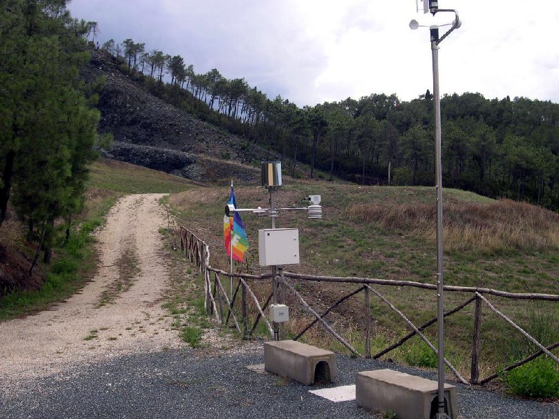 Accesso alla spianata: veduta verso la discarica dal belvedere, con la stazione di rilevamento meteorologico- mai entrata in funzione- e la bandiera della pace