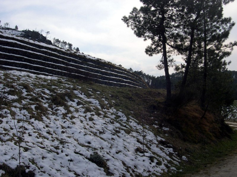 i gradoni che sorreggono il terreno a ricoprimento della discarica, in abito invernale.